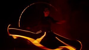 Performers interacting with synchronized digital scenography and LED arch.